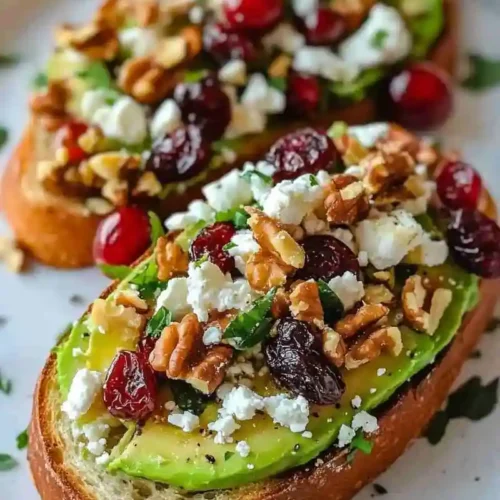 Savory avocado toast with feta, nuts, and cranberries on crisp sourdough