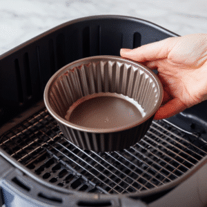 Carefully place the ramekin into the air fryer basket.