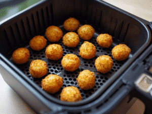 Lightly spray the air fryer basket with cooking spray and arrange the potato balls in a single layer without overcrowding.