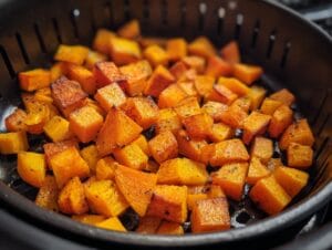 Toss the diced butternut squash with olive oil, salt, pepper, and cinnamon